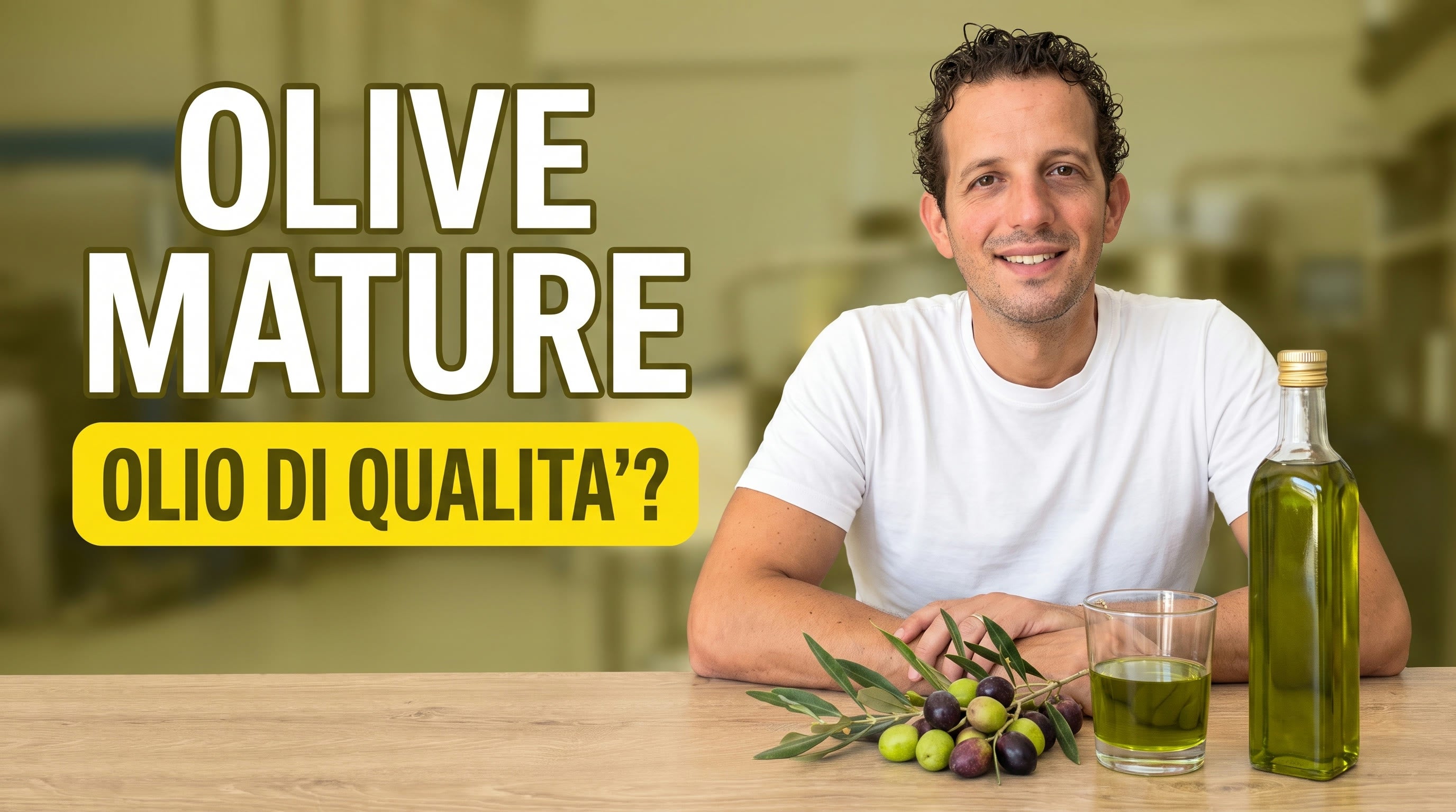 Antonio Carbone con un rametto di olive mature verdi e viola, un bicchiere di olio extravergine verde e una bottiglia: da olive mature si produce un extravergine di qualità