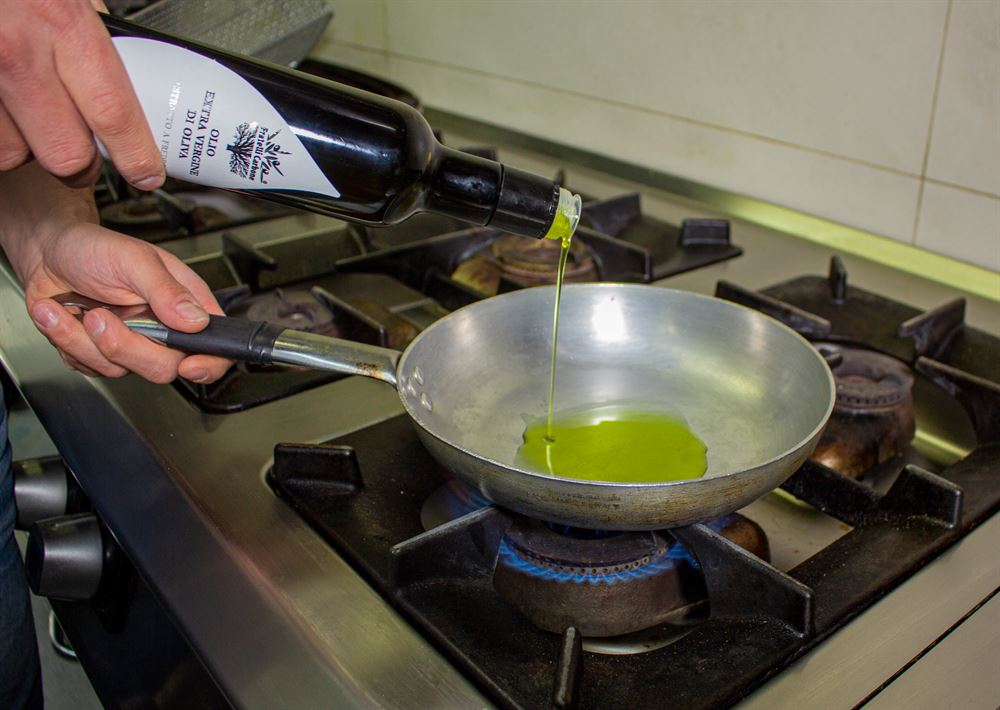 Olio extravergine: l'utilizzo in cucina. olio versato in padella